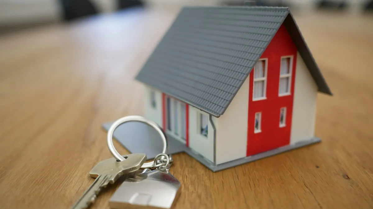 A miniature house and a set of keys on a table