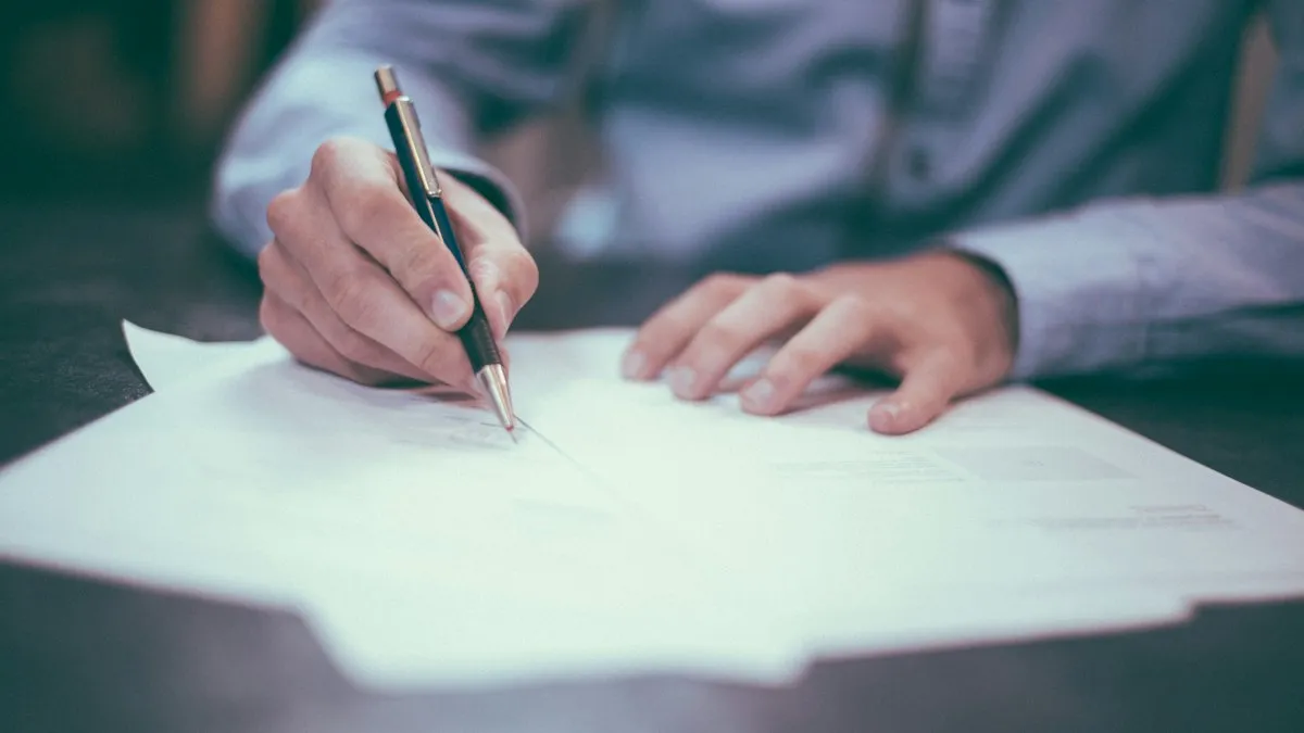 A person signs a document with a pen