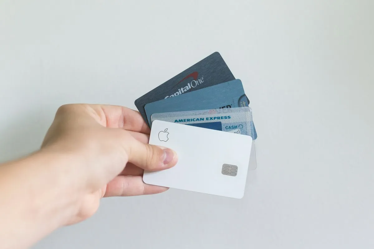A hand holding several credit cards
